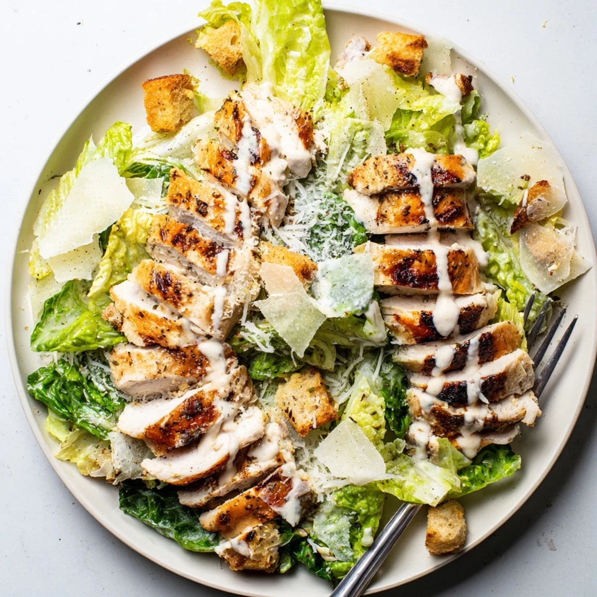 Juicy grilled chicken Caesar salad with homemade dressing and crispy romaine lettuce.  