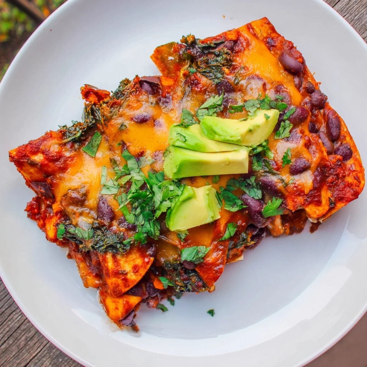Golden, bubbly cheese covers these one-pan sweet potato, black bean & kale enchiladas, ready to serve warm.