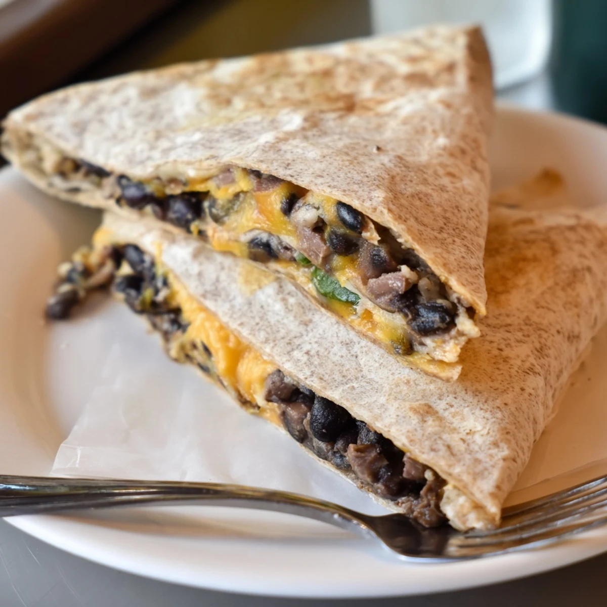 Crispy, layered tortilla wrap hack with refried beans reveals a cheesy, satisfying texture.