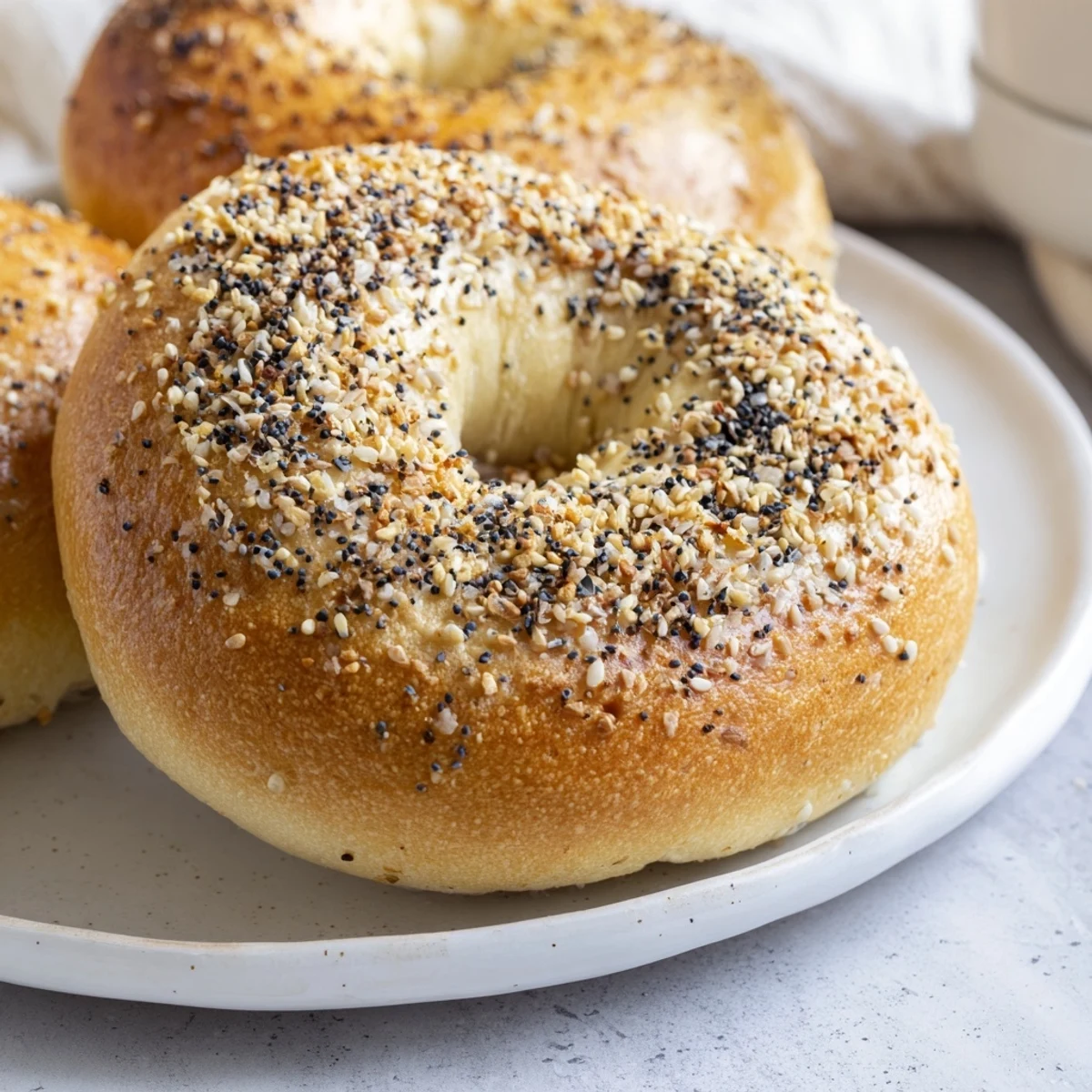 Freshly baked homemade budget bagels, glistening after boiling, ready for toppings and the oven.