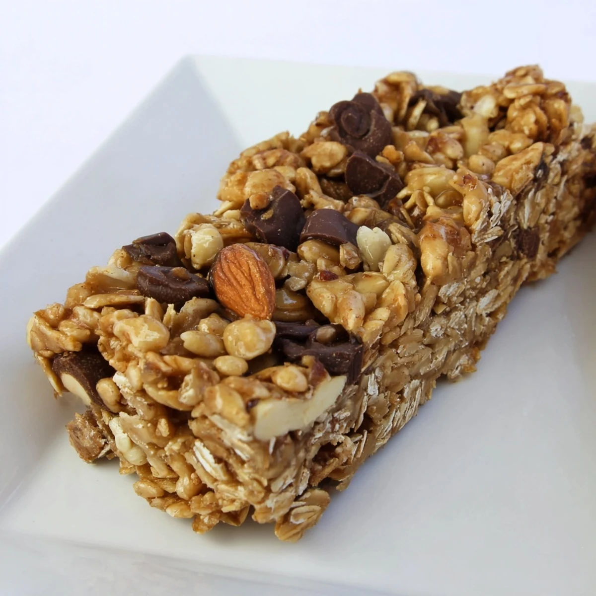Warm, golden-brown homemade granola bars, chewy and packed with oats and seeds, ready to eat.
