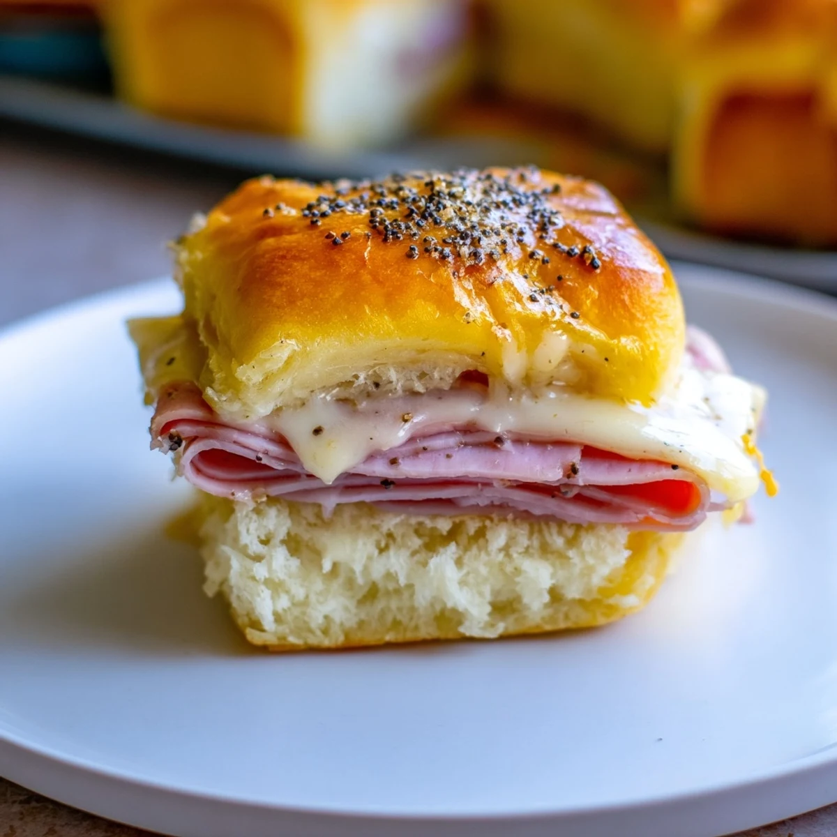 Golden-brown Baked Ham and Cheese Party Sliders, oozing cheese and ready to serve at your next party.