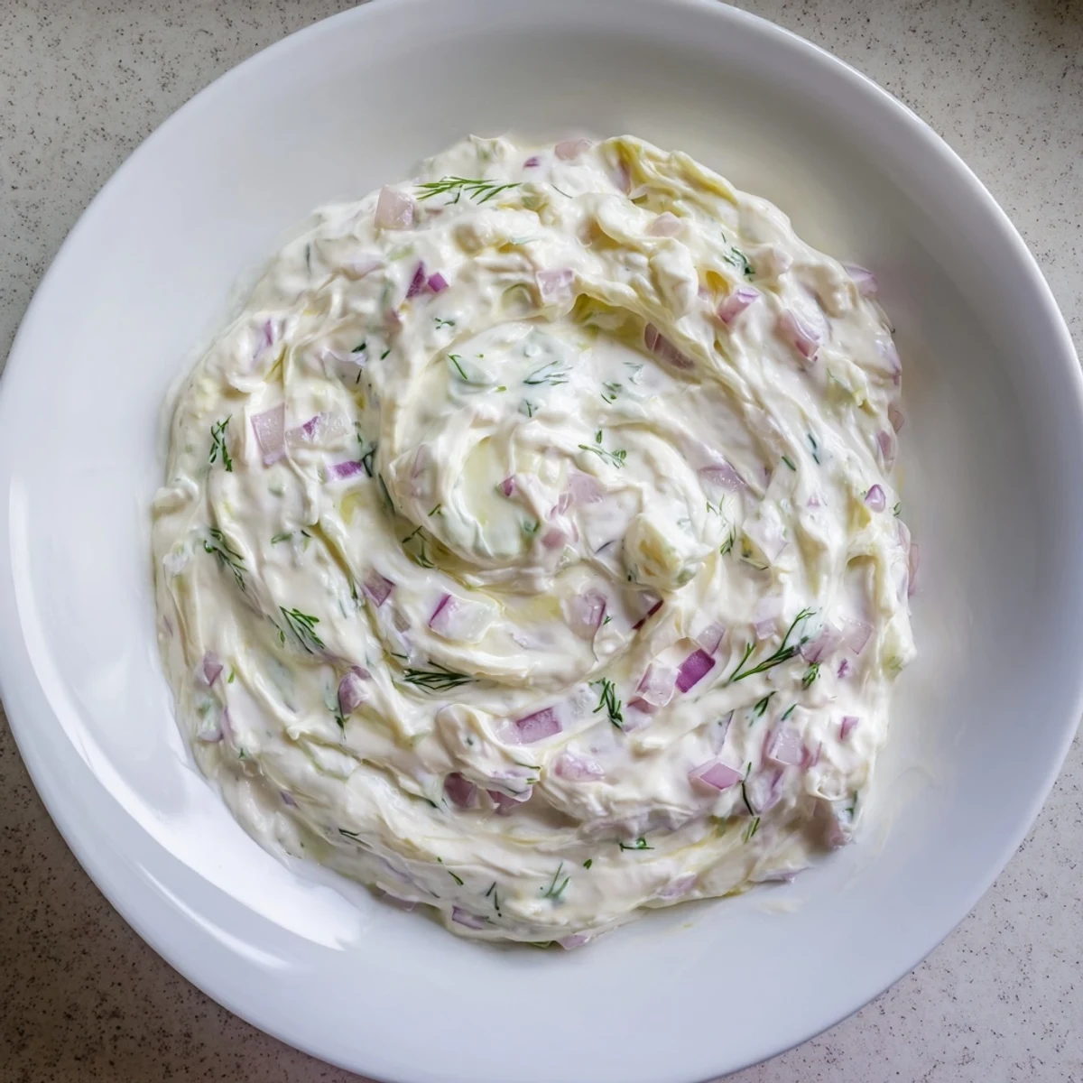 Creamy sweet and sour pickle relish dip with visible bits, perfect for dipping tortilla chips.