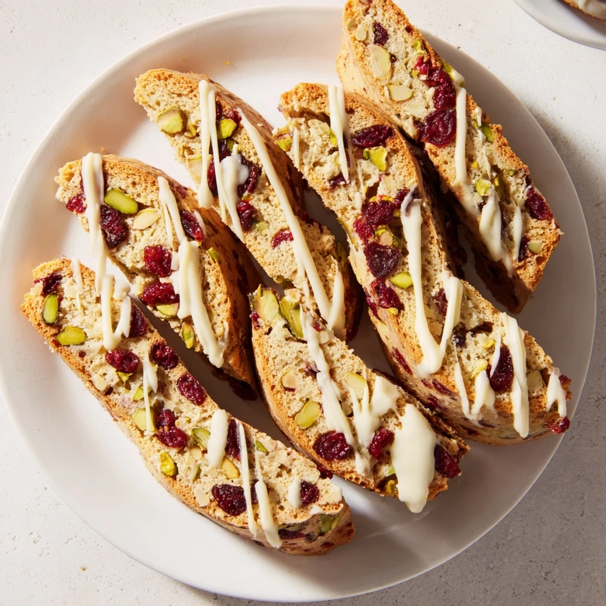 Golden, crispy White Chocolate Cranberry Pistachio Biscotti, drizzled with sweet white chocolate and ready to enjoy.
