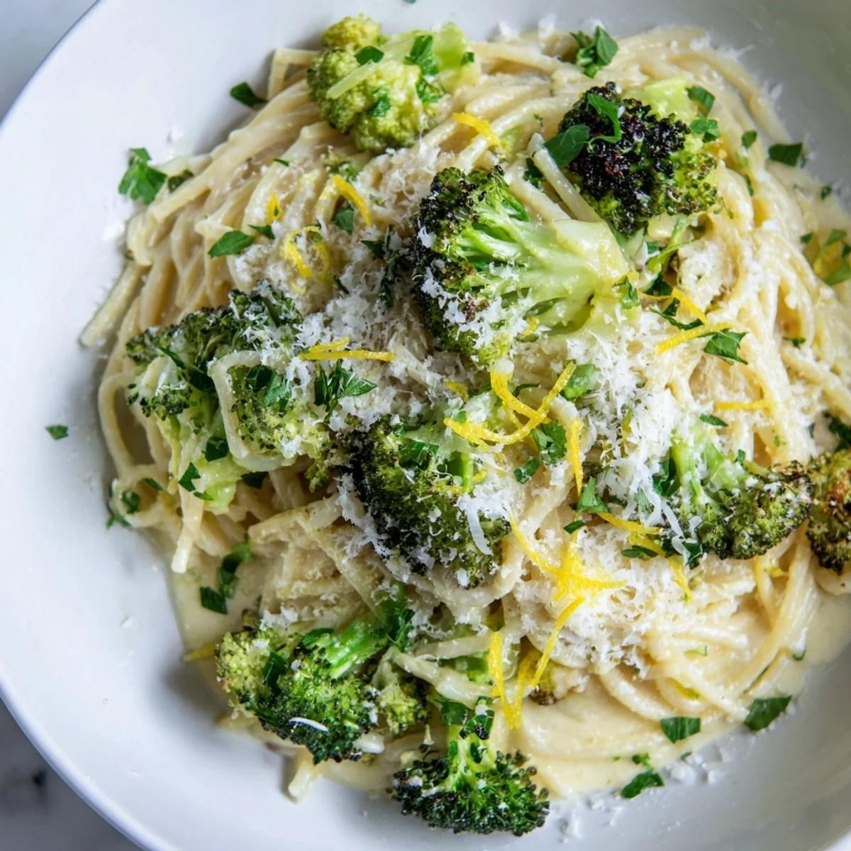 Roasted garlic lemon broccoli angel hair pasta sits ready, glistening with lemon and Parmesan.