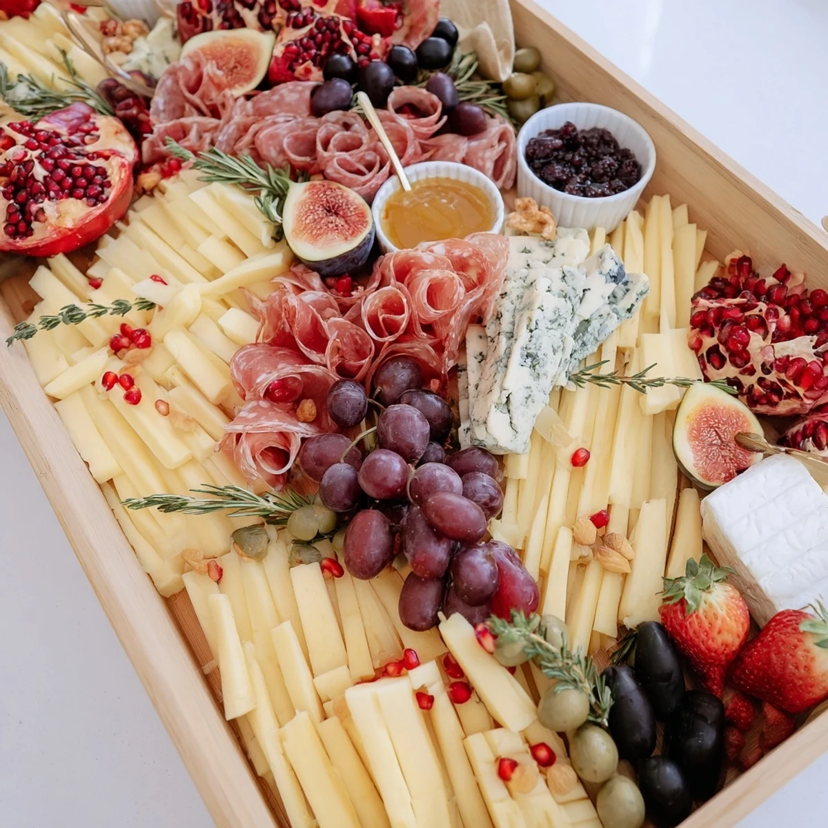 Luxurious The Final Curtain appetizer board featuring Brie, grapes, and prosciutto spilling over the platter's edge.