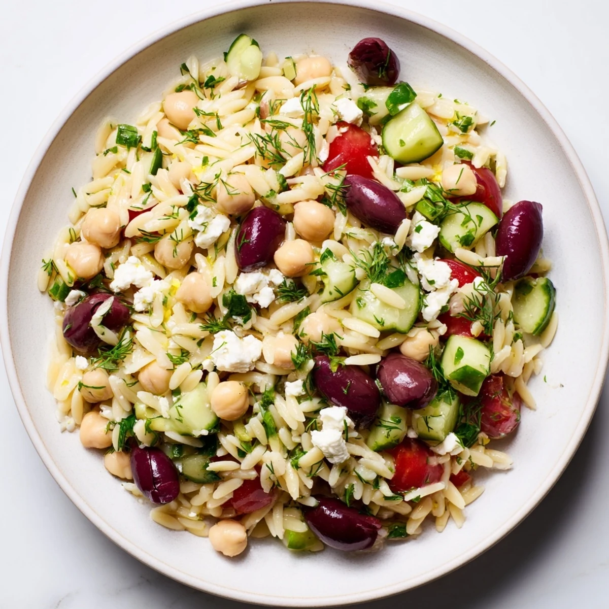 A bowl of refreshing Greek Lemon-Orzo Bean Salad with creamy chickpeas and tangy dressing, so delicious!