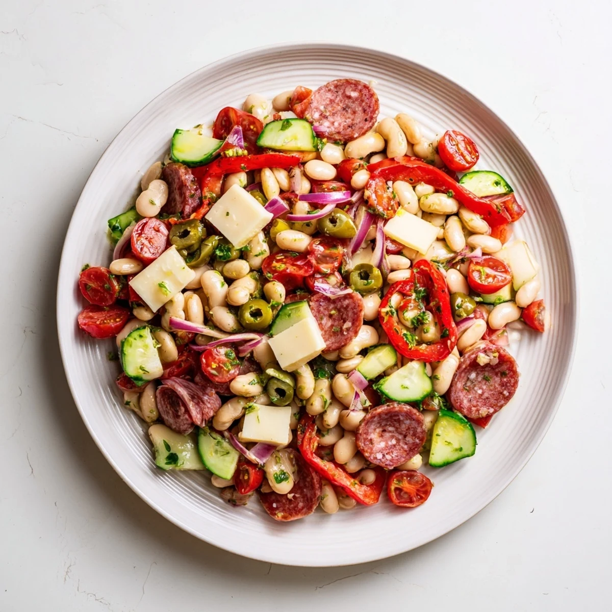 Italian Antipasto Bean Salad, brimming with colorful veggies, salami, cheese, and a zesty Italian dressing.