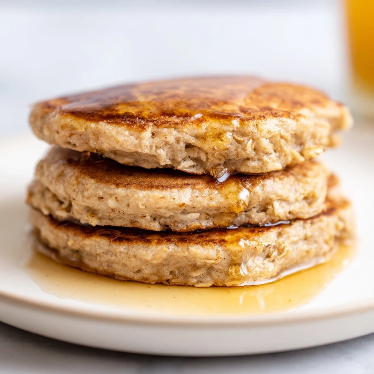 Stack of warm banana oat pancakes, showcasing their fluffy texture, ready for a delicious bite.