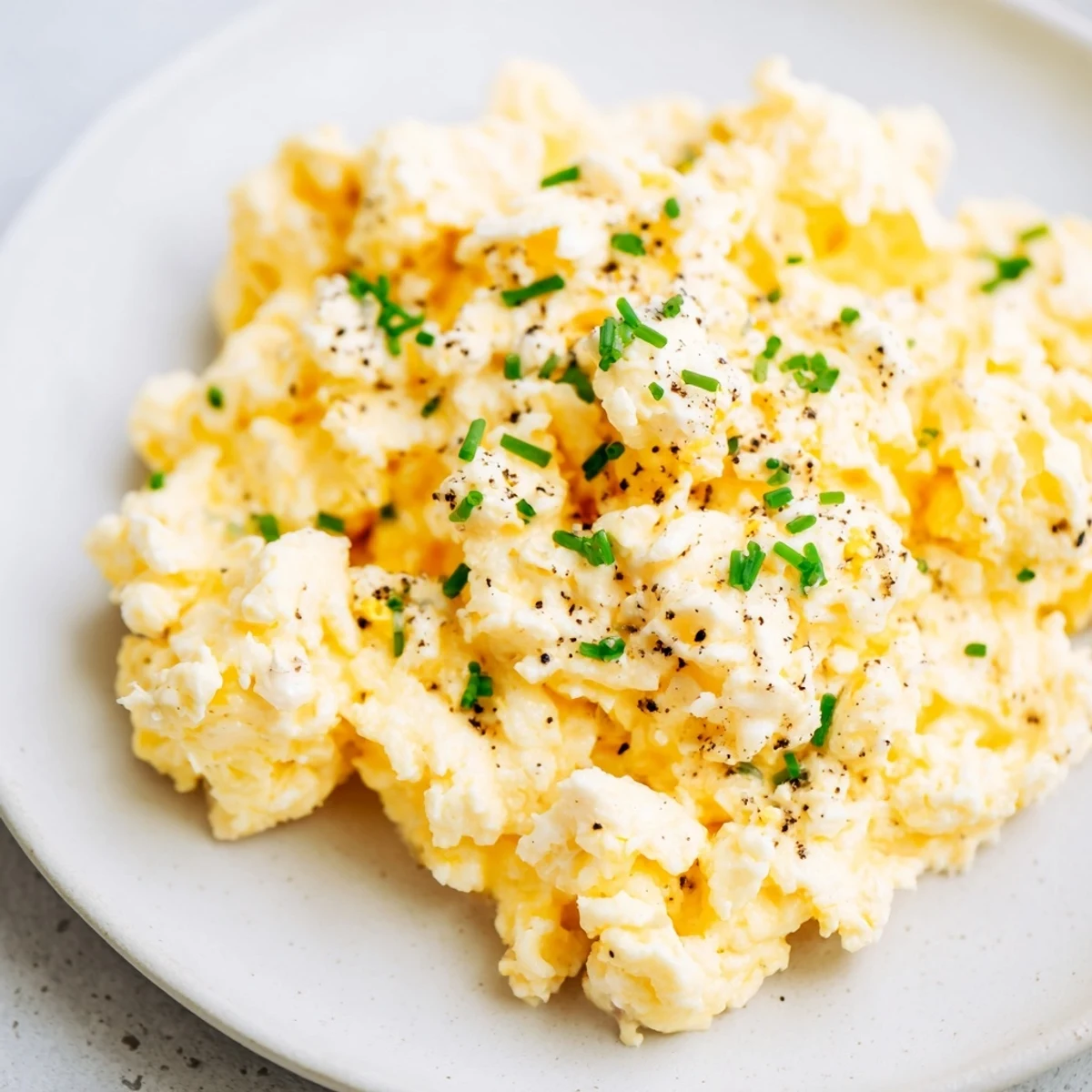 Fluffy Cottage Cheese Scrambled Eggs, seasoned and ready to eat, served on a warm plate.