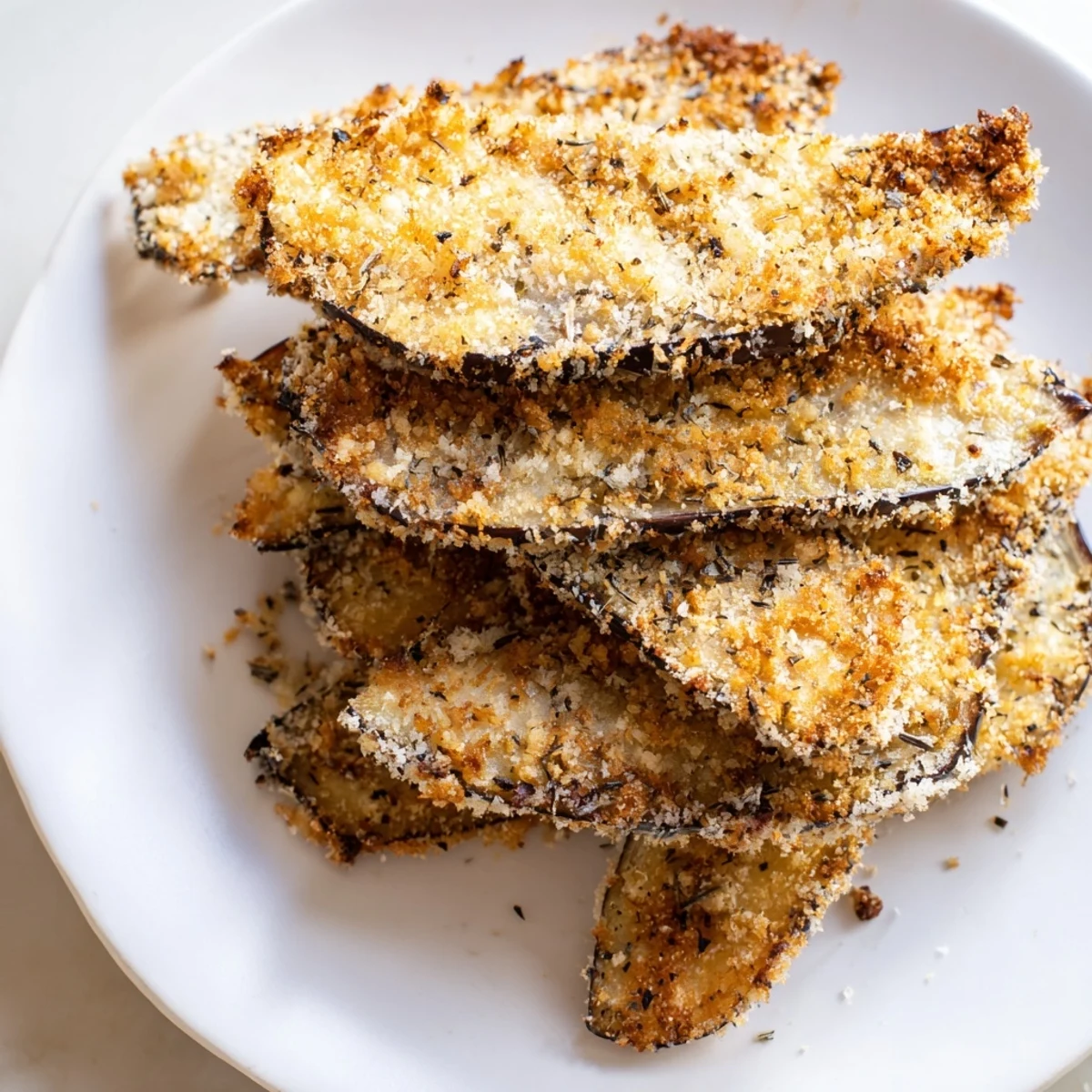Golden-brown Crispy Eggplant Parmesan Chips perfectly arranged, ready for dipping into marinara.