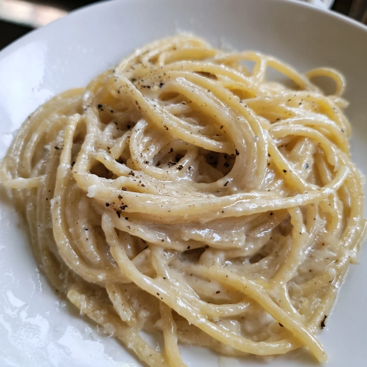 Steaming bowl of Lazy Girl Three-Ingredient Pasta, glistening with melted butter and Parmesan cheese.