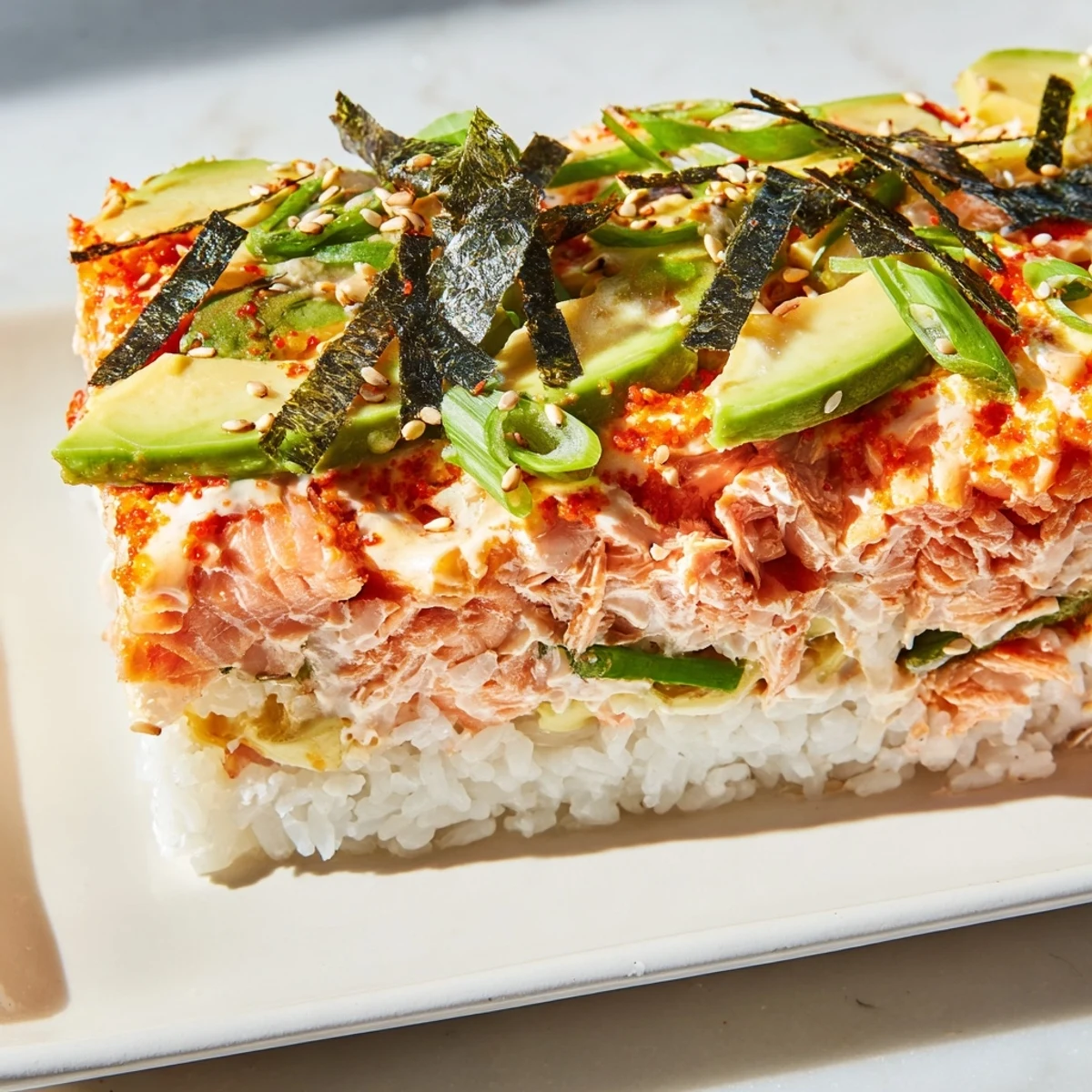 Melting cheese layered with salmon, rice, and nori beautifully compose this sushi bake.