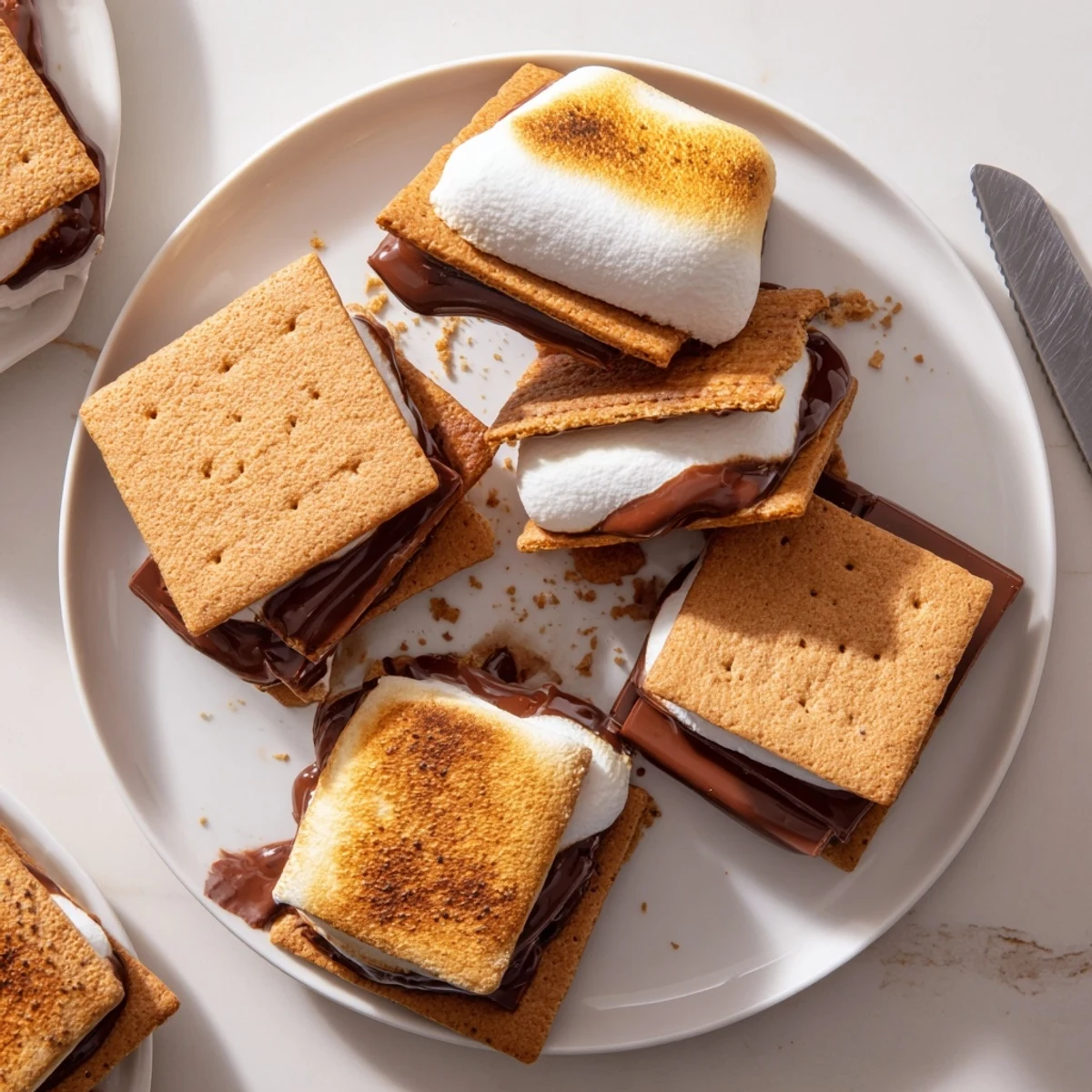 Golden marshmallows and melted chocolate sandwiched between crisp graham cracker squares, showing the gooey interior of an air-fried s'more.