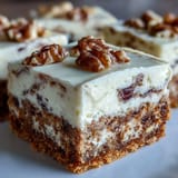 Irresistible layered dessert bars combining moist carrot cake, smooth cheesecake, and warm spices for the ultimate spring treat.
