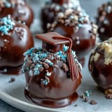 Festive graduation cake pops in school colors, each topped with a fondant cap and mini chocolate tassel.