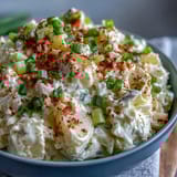 Classic Deviled Egg Potato Salad featuring chopped eggs, crunchy celery, and smoky paprika, ideal as a make-ahead side dish.  