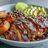 Healthy BBQ chicken meal prep bowls with fluffy sweet potato and fresh vegetable medley.