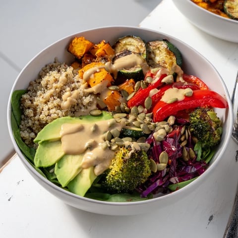 A colorful Roasted Veggie Buddha Bowl with Tahini Sauce and fresh greens.  