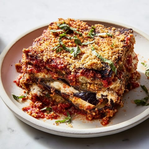 Close-up of bubbling Eggplant Parmesan Lasagna with melted mozzarella and golden crust, ready to serve.