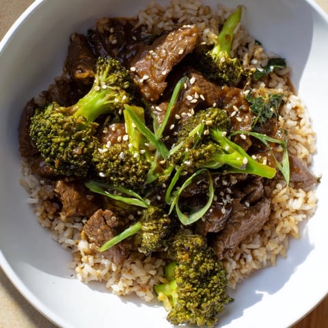 Tender slow-cooker beef and broccoli, a savory Asian-inspired dish over brown rice and mixed greens.