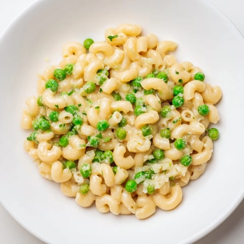 Steaming bowl of Macaroni & Peas, a creamy, comforting classic pasta dish.