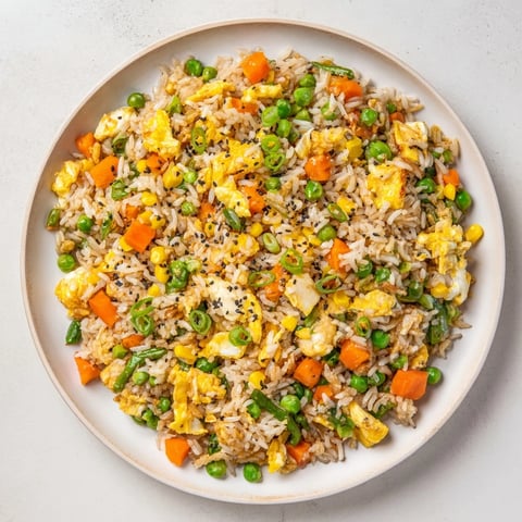 Steaming hot frozen veggie fried rice with colorful vegetables and fluffy scrambled eggs, perfect for lunch.