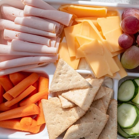 DIY Lunchables trays, perfectly arranged with meats, cheeses, crackers, and colorful veggies, ready to eat.