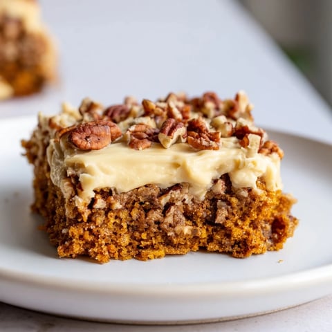 Warm pumpkin bars with rich brown sugar frosting, ready to serve, a delightful dessert.