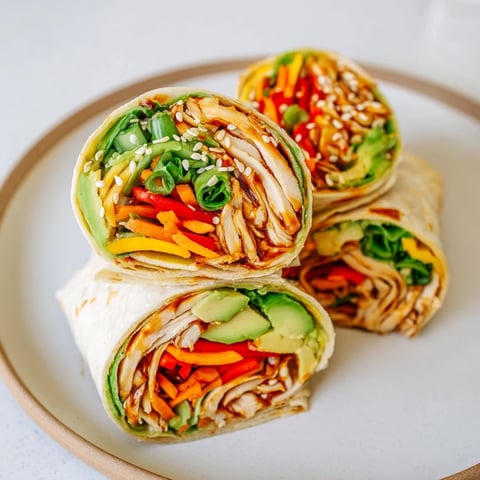 Close-up of a delicious teriyaki chicken wrap, showing a cross-section full of colorful ingredients.