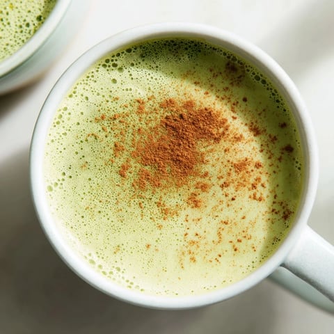 Steaming Cinnamon Maple Oat Milk Matcha Latte, a vibrant green vegan beverage, ready to be enjoyed.