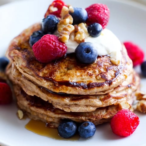 Golden-brown Brown Banana Pancakes sizzling on a skillet, ready to be flipped to a perfect crisp.