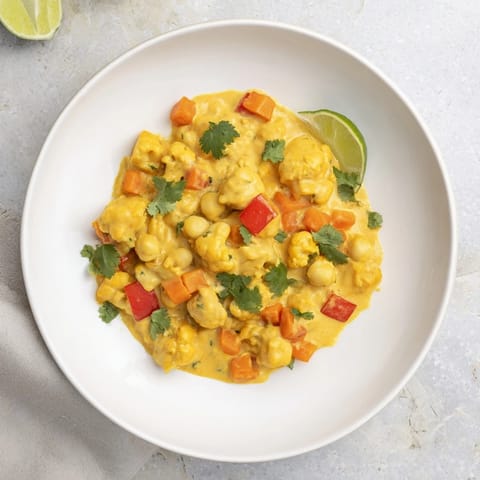A close-up shot of the rich, creamy curried cauliflower and chickpea coconut stew, perfect with fresh cilantro.
