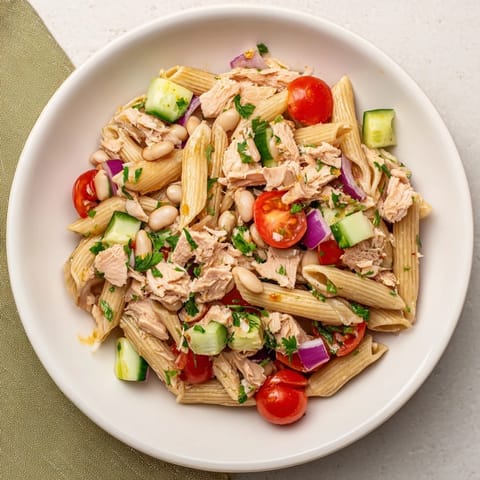 Enjoy a refreshing scoop of Spicy Tuna and White Bean Pasta Salad, perfect for a Mediterranean lunch.