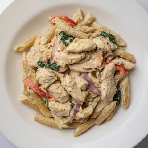 Delicious, warm Cajun Dirty Snow Chicken Pasta with tender chicken and a creamy sauce is pictured.