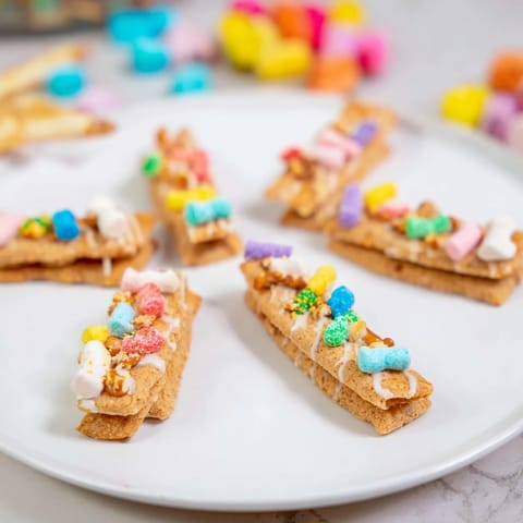 Vibrant Candy Land gingerbread path dessert board featuring gummy candies, sprinkles, and dipping sauces everyone will enjoy.