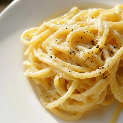 Creamy Lazy Girl Three-Ingredient Pasta is served, with a sprinkle of fresh parmesan for added flavor.
