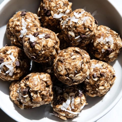 Small, round Almond-Chia Energy Bites speckled with chocolate chips, perfect for a grab-and-go treat.