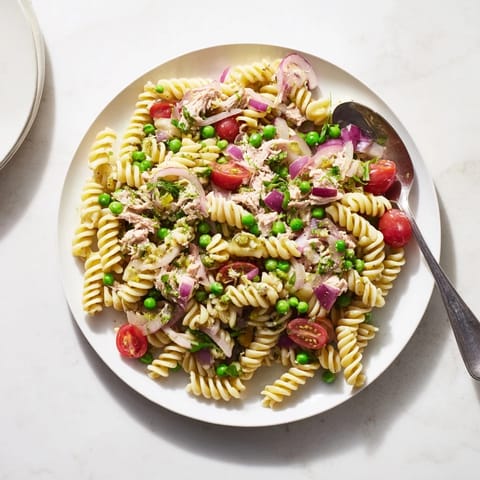 This easy Lemony Tuna Pasta Salad is served in a rustic white bowl, garnished with fresh dill, parsley, and lemon zest.