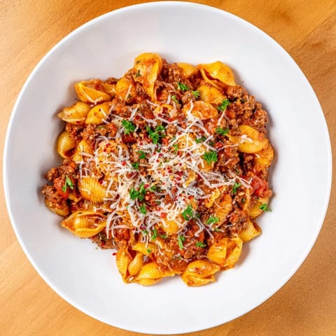 Creamy beef and shells simmer in a single pot, with melted cheddar and Parmesan creating a rich, velvety sauce topped with fresh parsley.