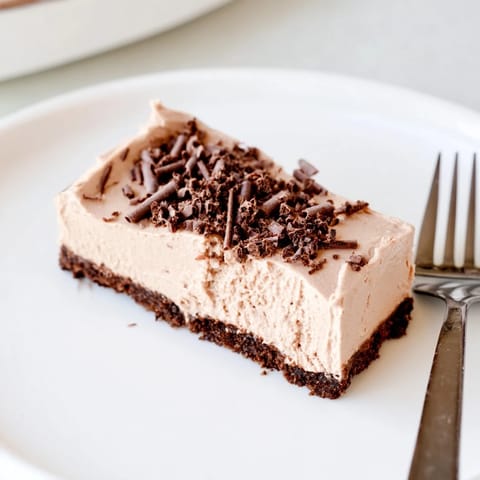 Sliced piece of Lighter Chocolate Cottage Cheese Cheesecake on a plate, ready to serve with fresh berries.