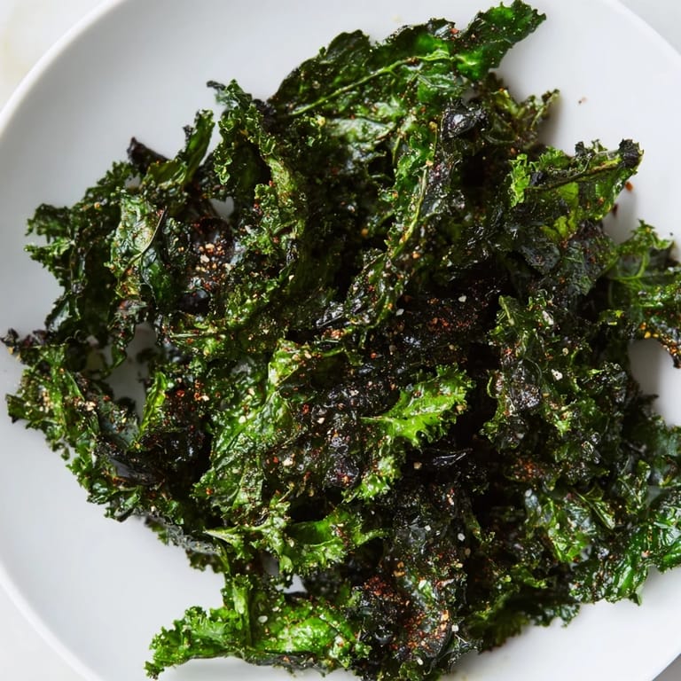 Close-up of freshly baked kale chips, seasoned and ready for a crunchy bite.