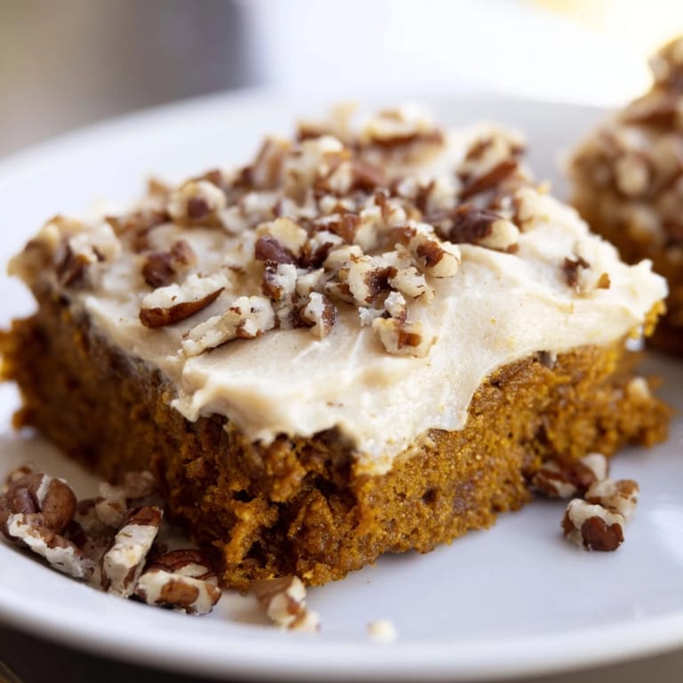 A close-up of frosted Pumpkin Bars, perfectly cut with a generous layer of frosting.