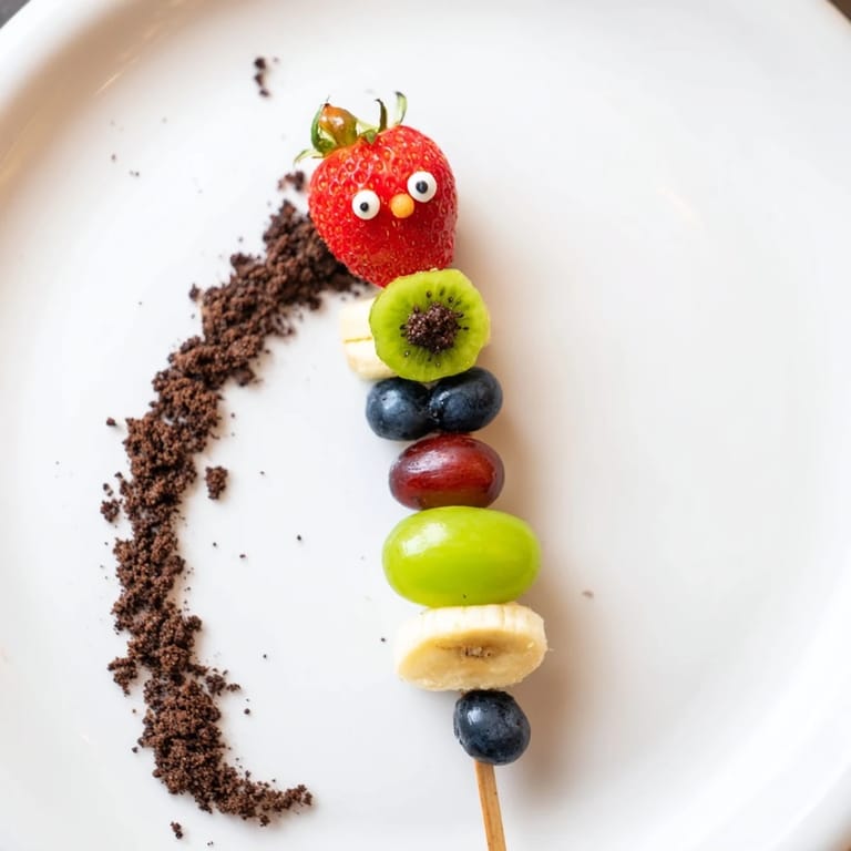 Fresh and fun Caterpillar Fruit Skewer Track with strawberries and grapes displayed on a crumb path.