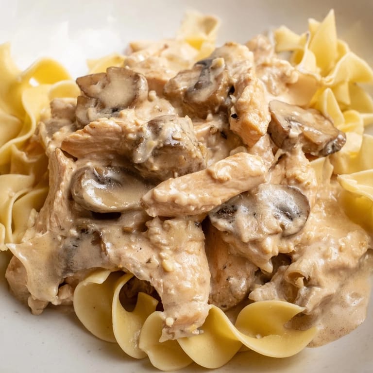 Hearty Chicken and Mushroom Stroganoff features succulent chicken and cremini mushrooms in a luscious, creamy sauce, perfect over a bed of steaming egg noodles.