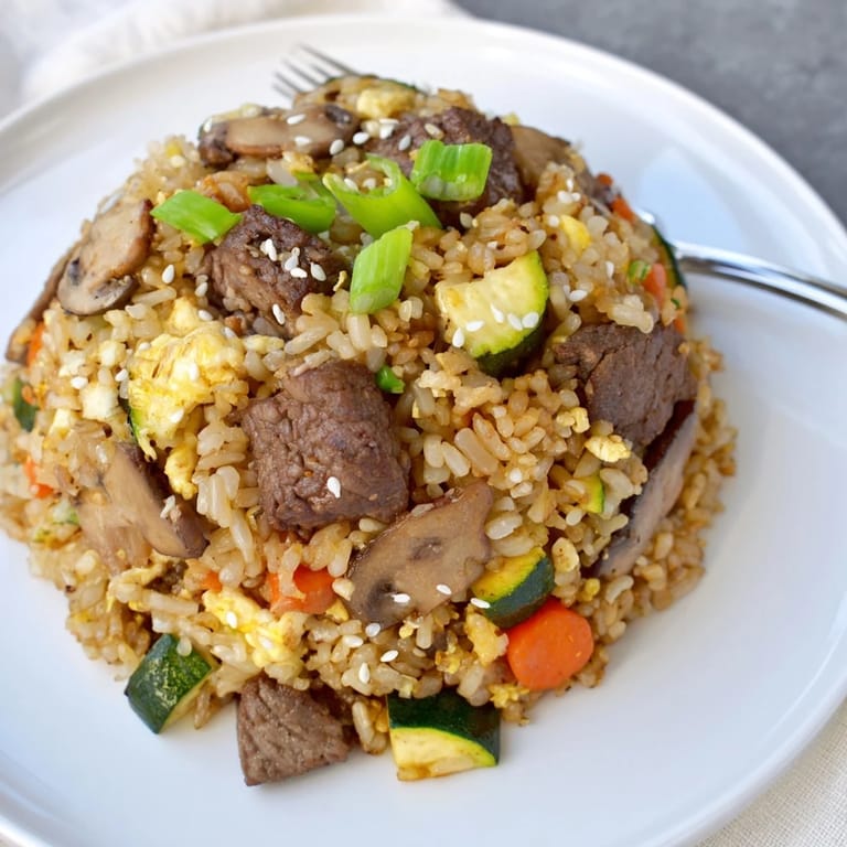 A close-up of golden fried rice with tender steak, peas, and carrots showcases this Easy Hibachi Steak With Fried Rice, perfect for weeknights.