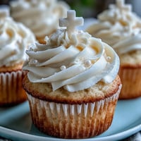 Beautiful vanilla cupcakes with creamy buttercream frosting and elegant white fondant cross toppers for First Communion celebrations.